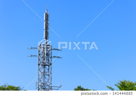 A television broadcasting station's transmission tower stands tall against the clear blue sky. 141444885