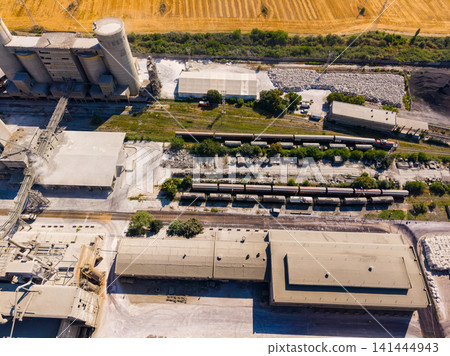 Concrete factory with several storage areas and trucks on a sunny day Concrete factory with several storage areas and trucks on a sunny day 141444943