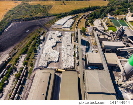 Industrial site with large storage area and machinery in the countryside during daylight hours Industrial site with large storage area and machinery in the countryside during daylight hours 141444944