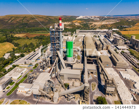 Large industrial plant located in a rural area with machinery working under clear blue sky during daytime Large industrial plant located in a rural area with machinery working under clear blue sky during daytime 141444973