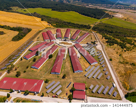 Solar farm in a rural area with buildings and open fields during daytime Solar farm in a rural area with buildings and open fields during daytime 141444975
