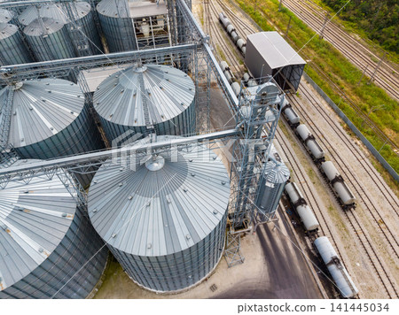 Grain storage facility with silos and train tracks near the loading area in an industrial setting Grain storage facility with silos and train tracks near the loading area in an industrial setting 141445034
