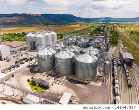 Large storage silos and railway near fields in rural area during daytime 141445037