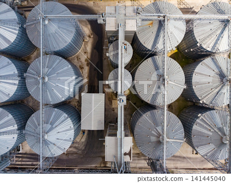 View of large grain silos and storage facilities from above on a sunny day in a rural area View of large grain silos and storage facilities from above on a sunny day in a rural area 141445040