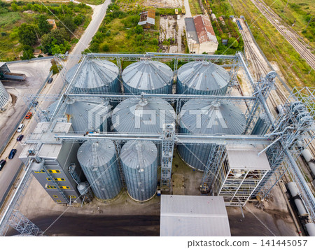 Grain storage facility with silos and surrounding landscape in a rural area during a clear day Grain storage facility with silos and surrounding landscape in a rural area during a clear day 141445057