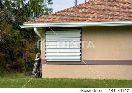 Hurricane shutters on Florida house windows. Home protection before natural disaster Hurricane shutters on Florida house windows. Home protection before natural disaster 141445107