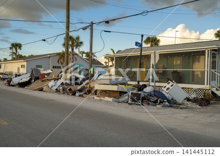 Hurricane damage in Florida. Piles of rubbish on street side from destroyed houses. Consequences of natural disaster Hurricane damage in Florida. Piles of rubbish on street side from destroyed houses. Consequences of natural disaster 141445112
