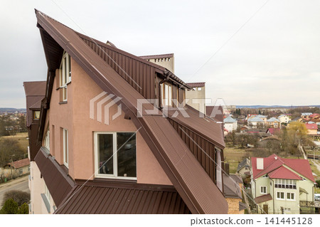 High apartment building with many windows and metal sheets roof. High apartment building with many windows and metal sheets roof. 141445128
