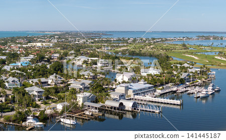 Expensive waterfront houses between green palm trees in Boca Grande, small town on Gasparilla Island in southwest Florida. Premium housing development in the USA 141445187