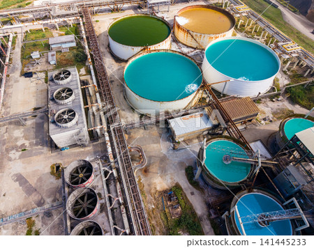 Water treatment facility shows various tanks with different colored water in a large industrial area during the daytime Water treatment facility shows various tanks with different colored water in a large industrial area during the daytime 141445233