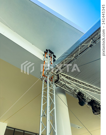 Structure supports a stage setup in a modern building during an event preparation process in daylight Structure supports a stage setup in a modern building during an event preparation process in daylight 141445345