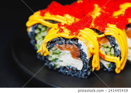 Sushi rolls with colored toppings on a plate served at a restaurant during dinner time Sushi rolls with colored toppings on a plate served at a restaurant during dinner time 141445439