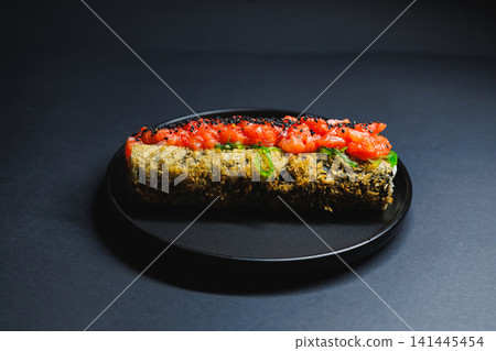 Delicious food on a black plate with toppings and fine details seen clearly Delicious food on a black plate with toppings and fine details seen clearly 141445454