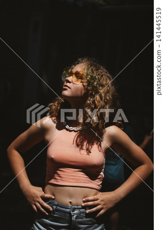 Teen Girl in Sunglasses Enjoying Sunlight Outdoors Teen Girl in Sunglasses Enjoying Sunlight Outdoors 141445519