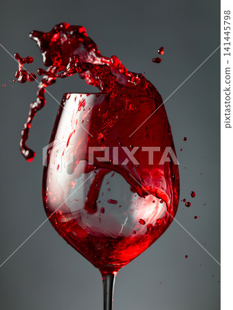 An image of red wine being splashed into a glass. 141445798