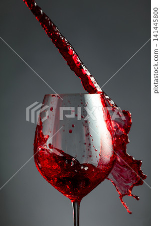An image of red wine being splashed into a glass. 141445800
