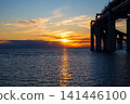 Scenic golden sunset over the calm sea with modern highway bridge on the right. Beautiful orange sky reflecting in water ripples. Kanonersky island in Saint Petersburg. Freedom and travel concept. 141446100