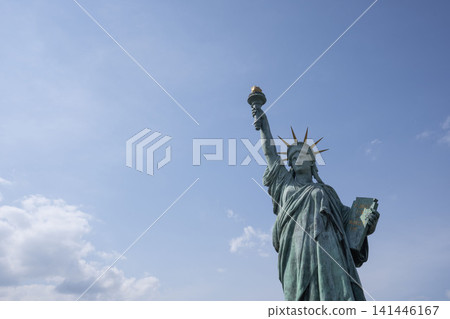 A distant view of the Statue of Liberty in Odaiba, standing against a backdrop of blue sky and beautiful clouds. A distant view of the Statue of Liberty in Odaiba, standing against a backdrop of blue sky and beautiful clouds. 141446167