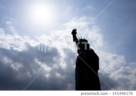 The silhouette of the Statue of Liberty in Odaiba, silhouetted against a backlit sky and dramatic clouds. The silhouette of the Statue of Liberty in Odaiba, silhouetted against a backlit sky and dramatic clouds. 141446176