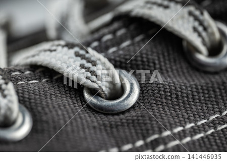 Shoe showing macro detail of canvas texture, metal eyelet, and patterned shoelace Shoe showing macro detail of canvas texture, metal eyelet, and patterned shoelace 141446935