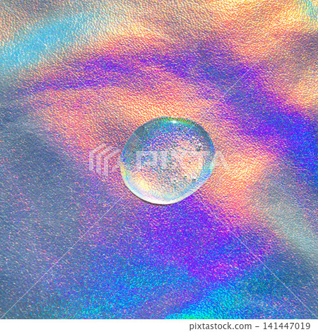 Iridescent holographic surface with a single water drop reflecting rainbow light and metallic texture 141447019