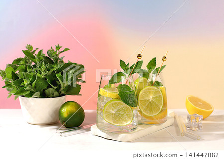 Icy homemade lemonade, juice or cocktail with mint, spearmint, lime, lemon and citrus, a refreshing summer drink recipe, a detox diet and weight loss concept, nonalcoholic mojito for energy Icy homemade lemonade, juice or cocktail with mint, spearmint, lime, lemon and citrus, a refreshing summer drink recipe, a detox diet and weight loss concept, nonalcoholic mojito for energy 141447082
