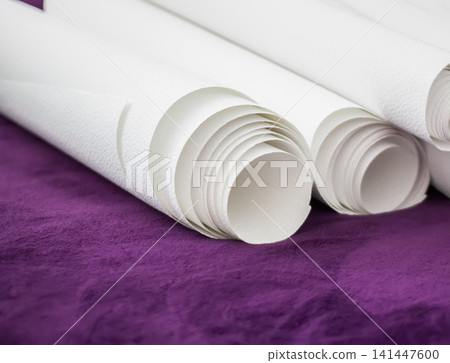 Selection of wallpaper rolls displayed indoors with modern decorative patterns and textures. 141447600