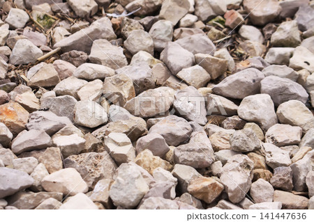 Decorative crushed stone pile with soft neutral tones for garden and outdoor paths. 141447636