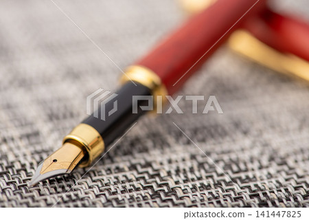 Fountain pen, beautiful fountain pen with details on a rustic surface with braided wires, selective focus. Fountain pen, beautiful fountain pen with details on a rustic surface with braided wires, selective focus. 141447825