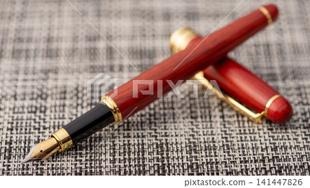 Fountain pen, beautiful fountain pen with details on a rustic surface with braided wires, selective focus. Fountain pen, beautiful fountain pen with details on a rustic surface with braided wires, selective focus. 141447826