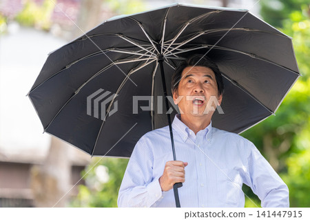 一位老人撐著陽傘預防中暑。 141447915
