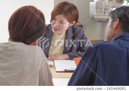 一對中年夫婦正在聽取有關退休金福利的解釋。 一對中年夫婦正在聽取有關退休金福利的解釋。 141448081