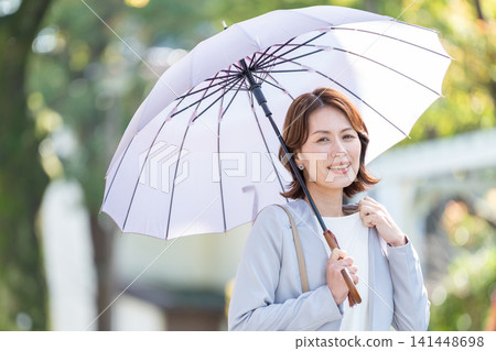 Business woman pointing a parasol Business woman pointing a parasol 141448698
