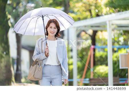 Business woman pointing a parasol Business woman pointing a parasol 141448699