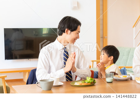 Father and son praying together at breakfast Father and son praying together at breakfast 141448822