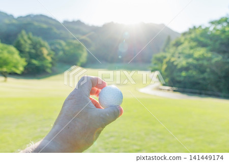 Close-up of someone holding a golf ball in their hand. Close-up of someone holding a golf ball in their hand. 141449174