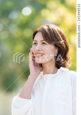 感覺皮膚水分的中年女人 感覺皮膚水分的中年女人 141449532