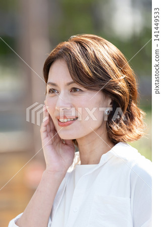 中年婦女把手放在臉頰上 中年婦女把手放在臉頰上 141449533