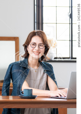 Middle woman using a computer in the living room Middle woman using a computer in the living room 141449536