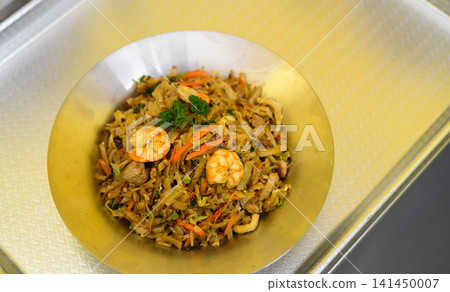 Seafood kottu roti with prawns served on a metal plate Seafood kottu roti with prawns served on a metal plate 141450007