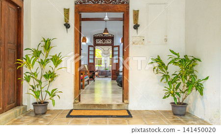 Elegant colonial villa doorway with warm hanging lantern and view into a traditional interior Elegant colonial villa doorway with warm hanging lantern and view into a traditional interior 141450020