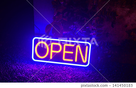 Open neon sign glowing in blue and yellow light for a retail storefront or business entrance Open neon sign glowing in blue and yellow light for a retail storefront or business entrance 141450183