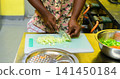 Chef slicing lettuce for a vegetable salad. Fresh ingredients being prepared in a professional kitchen 141450184