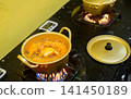 Korean ramen cooking in a pot on a gas stove with boiling broth in a restaurant kitchen 141450189