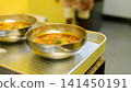 Two spicy ramen noodle soups with egg, ready to be served on a metal plate 141450191