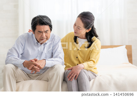 A depressed husband in bed and his supportive wife A depressed husband in bed and his supportive wife 141450696