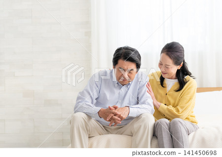A depressed husband in bed and his supportive wife A depressed husband in bed and his supportive wife 141450698