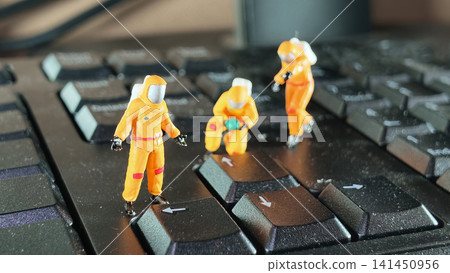 Miniature Hazmat Workers Cleaning Computer Keyboard Surface Miniature Hazmat Workers Cleaning Computer Keyboard Surface 141450956