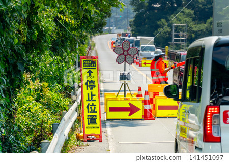 道路施工人員在烈日下指揮交通。 141451097