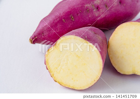 Close-up of a cross-section of a sweet potato harvested in autumn. Close-up of a cross-section of a sweet potato harvested in autumn. 141451709